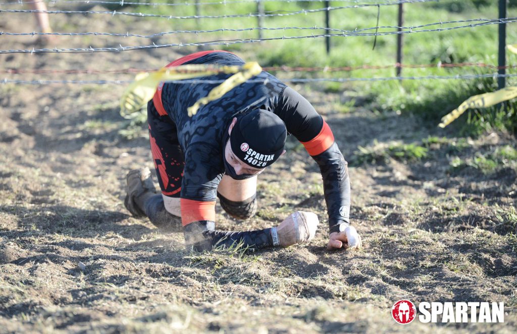 Joshua Marron crawling under barbwire at Spartan Race