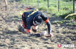 Joshua Marron crawling under barbwire at Spartan Race