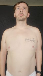 Close-up of Joshua Marron’s chest and abs facing forward in white briefs for Project Legacy vegan body transformation tracking.