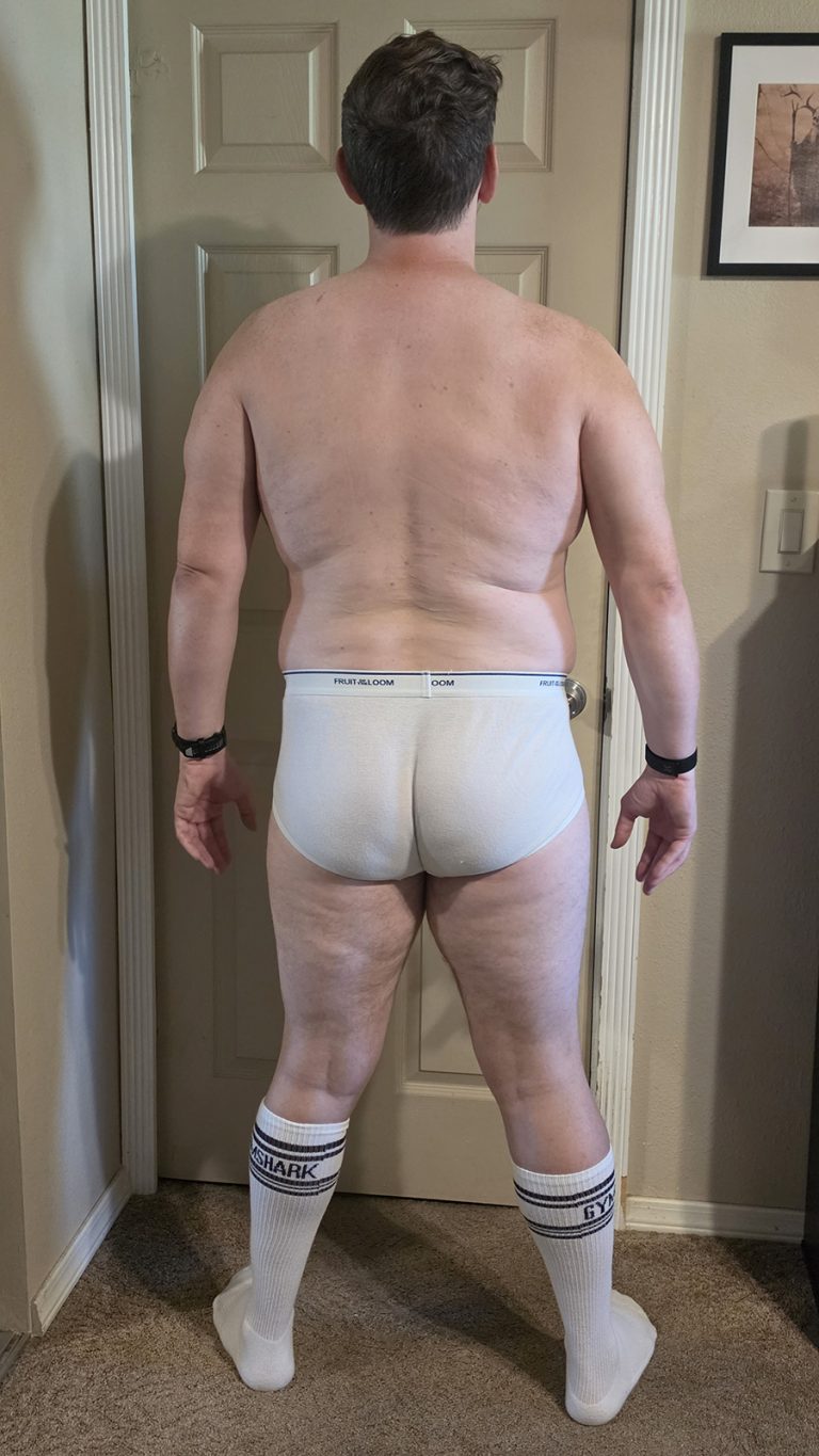 Week 2 progress photo of Joshua Marron in white briefs and socks, standing in a Back pose for the Resurgam transformation.