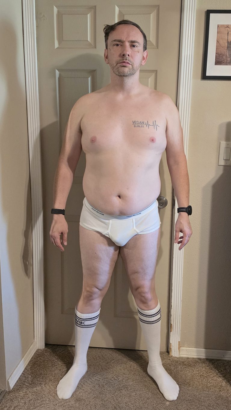 Week 2 progress photo of Joshua Marron in white briefs and socks, standing in a Front pose for the Resurgam transformation.